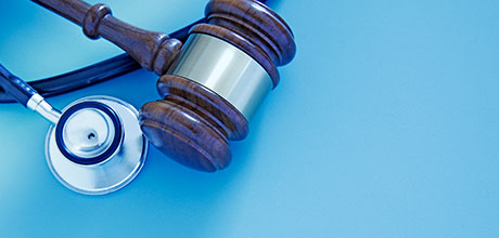 stethoscope and gavel on blue background