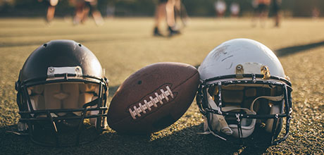 football and football helmets on a football field