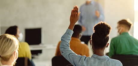 student with hand raised in classroom