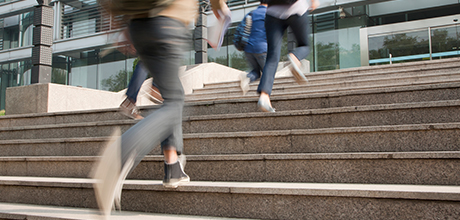 people running up steps to building