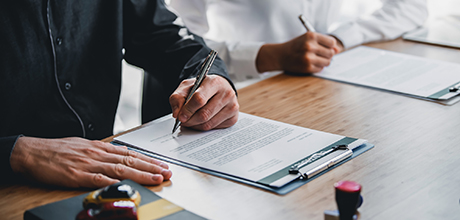 Two people signing contract