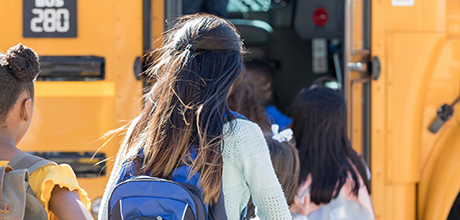 Girl getting on school bus