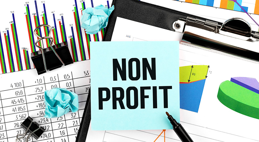a sticky note that reads 'non profit' on top of charts and binder clips