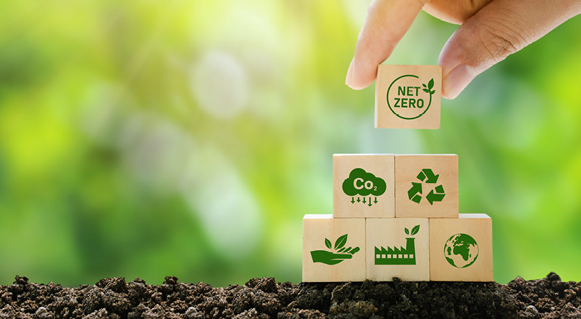 a hand stacking blocks with icons related to energy and net zero.