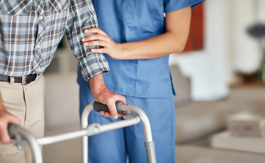 Nurse helping person with a walker