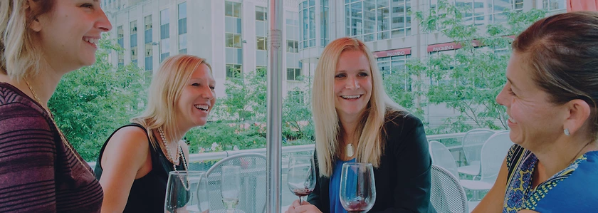 Lyndsey Barnett sits at a table laughing with 3 others.