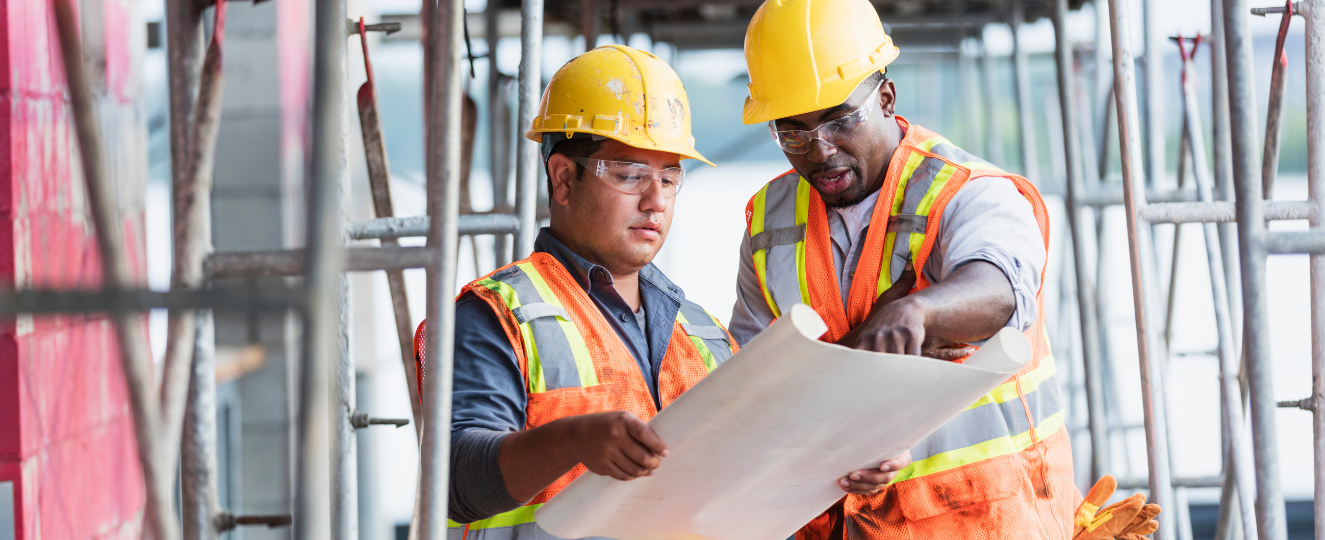 Workers at construction site looking at plans
