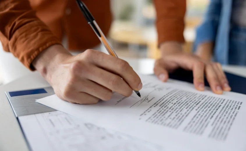 Person signing a deed while buying a property