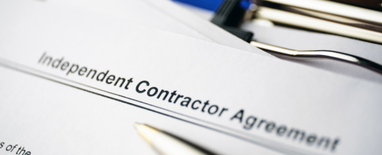 Independent Contractor Agreement and pen on clipboard